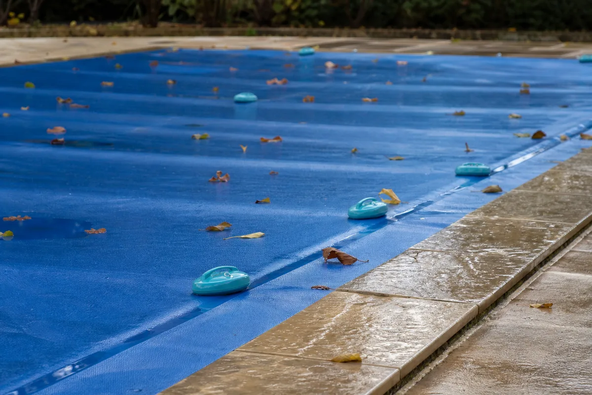 Piscine de jardin en hivernage dans le Sud-Ouest, bassin couvert sous une lumière dorée d’automne